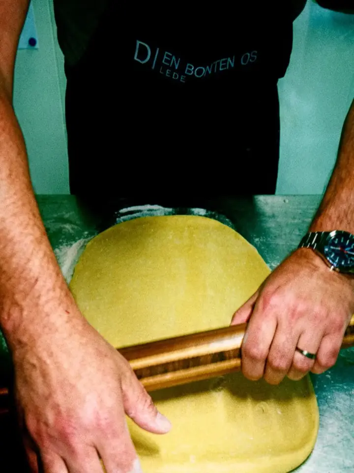 Verse pasta wordt uitgerold in de keuken